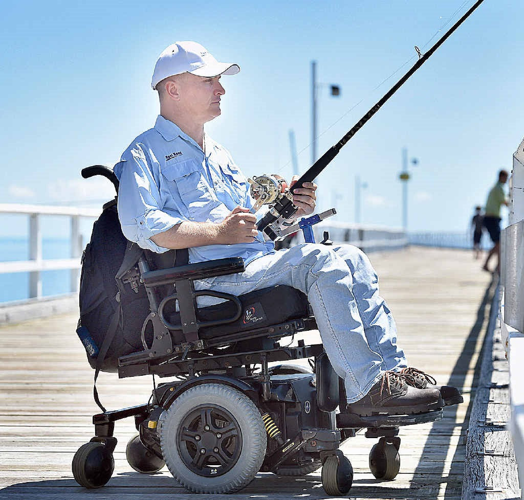 Hands-On adaptive fishing rod holder for under wheelchair seat - man in wheelchair on pier hand cranked reel