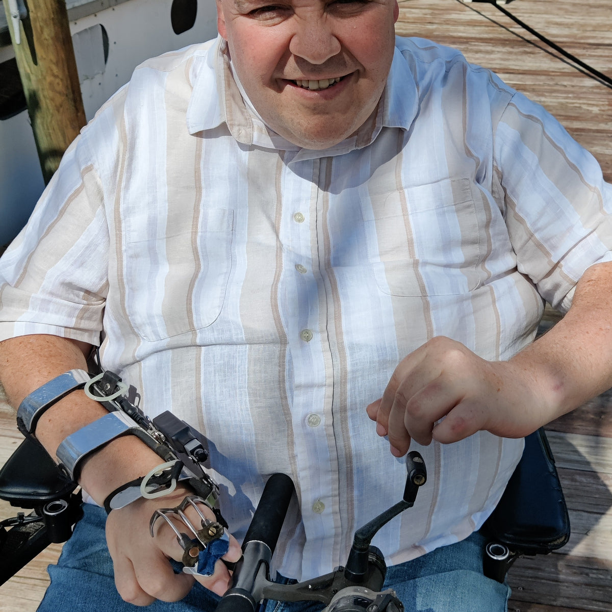 Hands-on wheelchair seat  adaptive fishing rod holder with manual reel-quadriplegic man Mark felling in wheelchair on dock